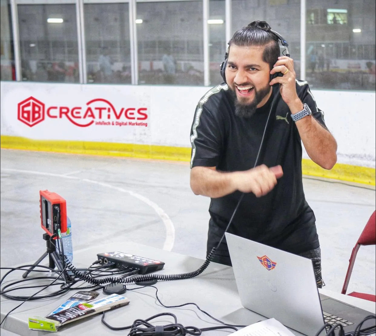 Chabi Dhakal managing event production with a headset, laptop and technical equipment